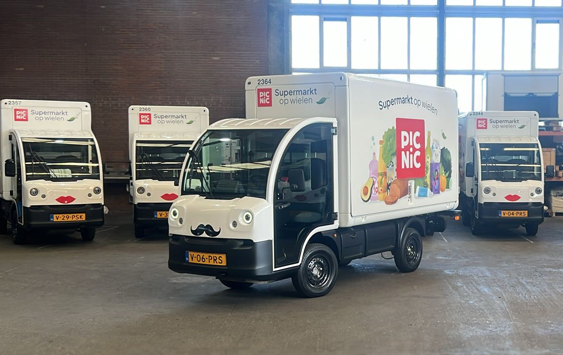 Een rij elektrische Picnic-bezorgwagens op basis van de Goupil G4 in een hal